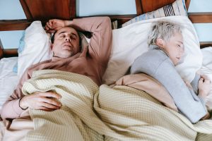 man and woman asleep on bed.