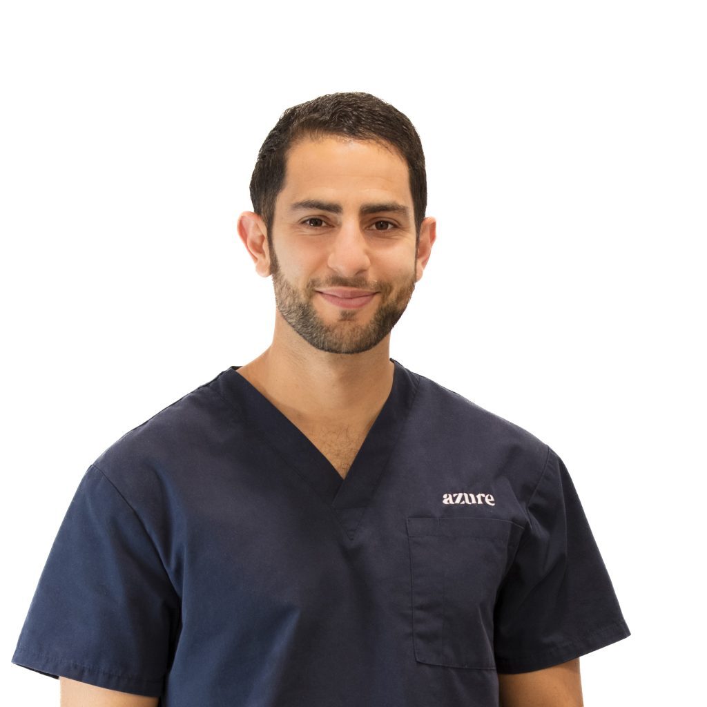 Michale Furfaro smiles at the camera, wearing the azure scrubs.